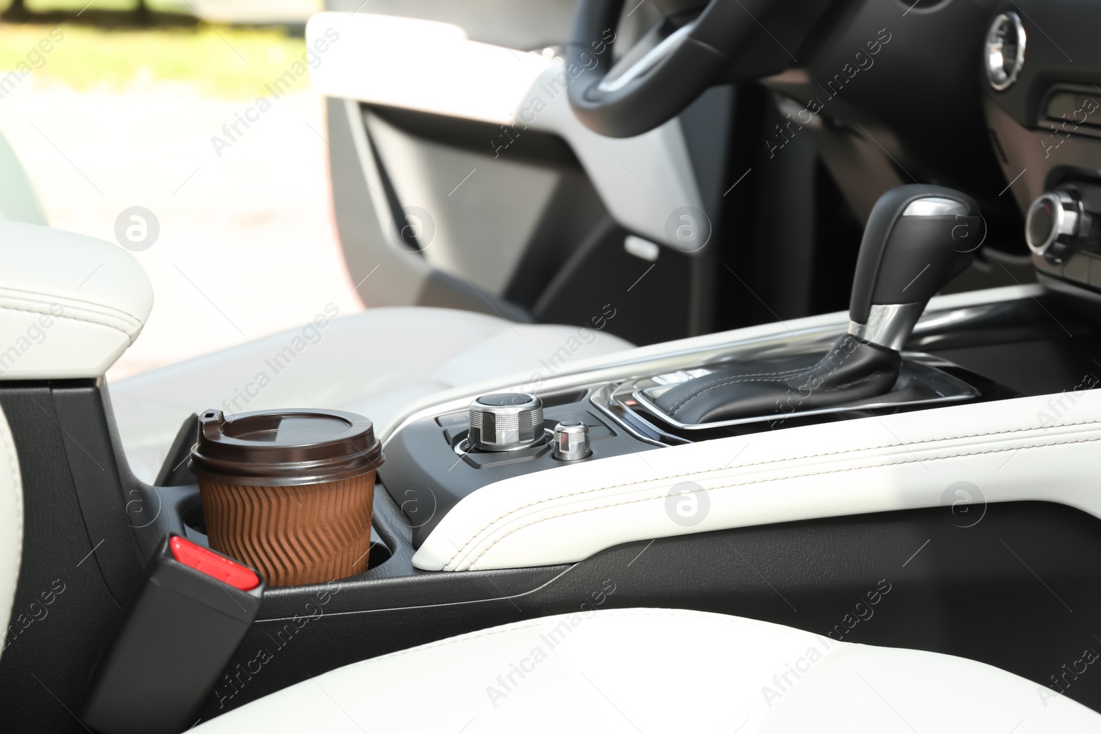 Photo of Takeaway paper coffee cup in holder inside car