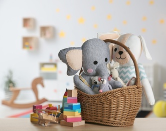 Set of different cute toys on wooden table in children's room