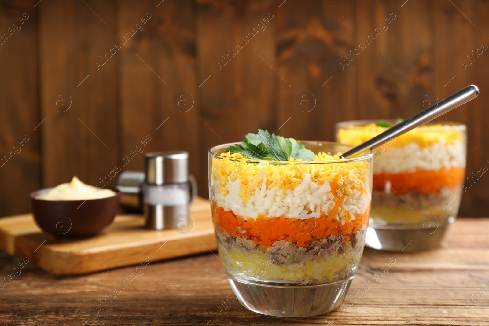 Photo of Traditional russian salad Mimosa served on wooden table, space for text