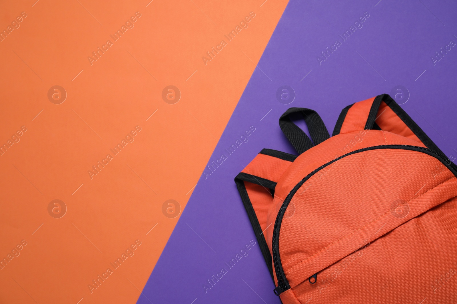 Photo of Stylish orange backpack on color background, top view. Space for text