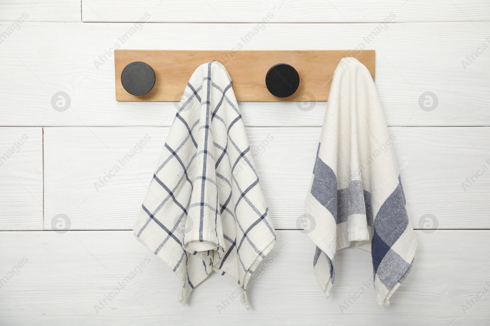 Photo of Different clean kitchen towels hanging on rack