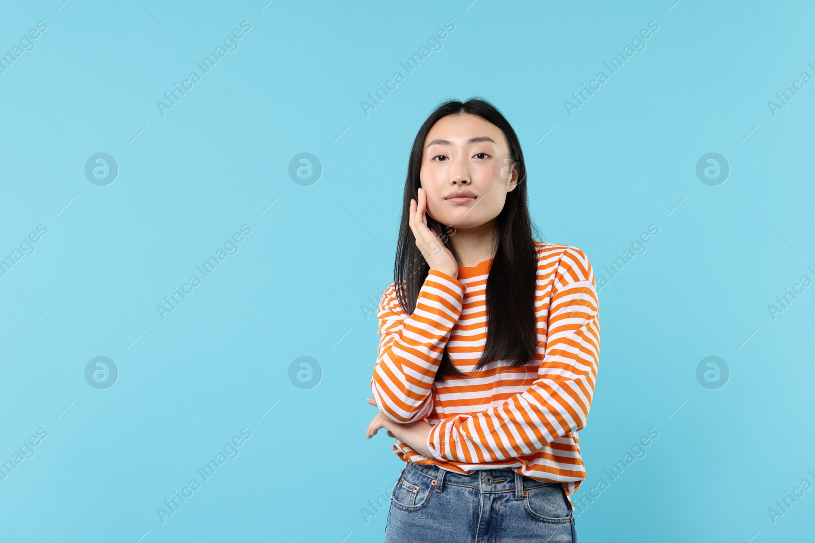 Photo of Portrait of cute woman on light blue background. Space for text