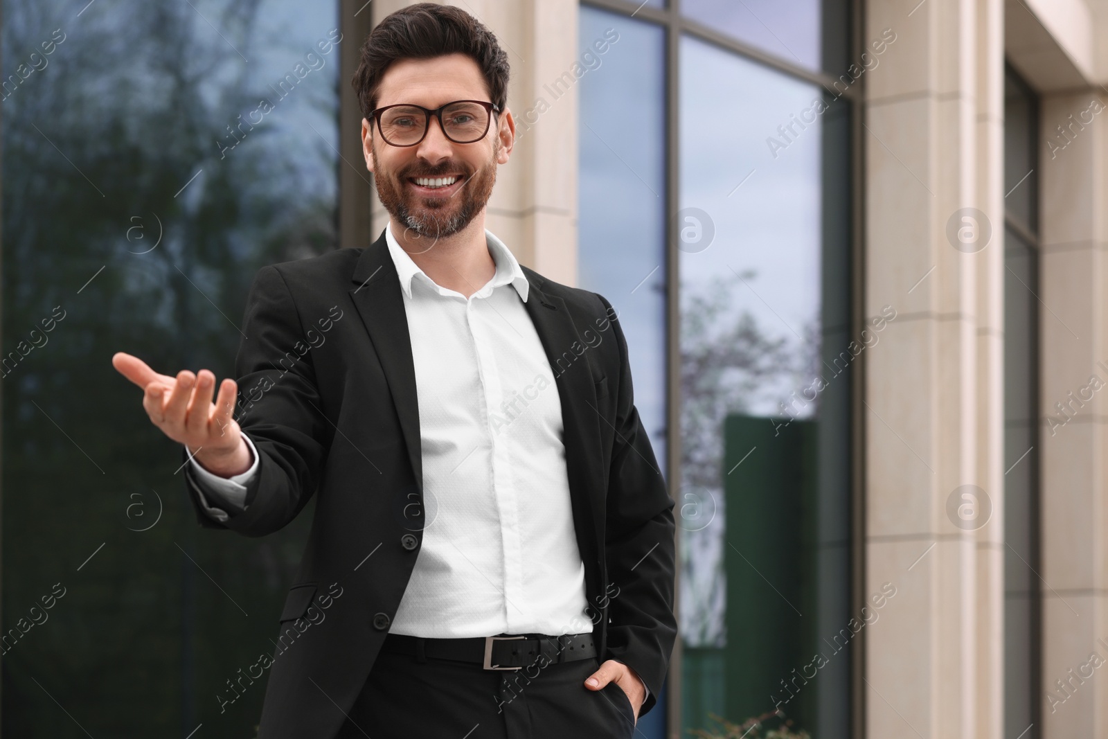 Photo of Happy real estate agent in suit outdoors. Space for text