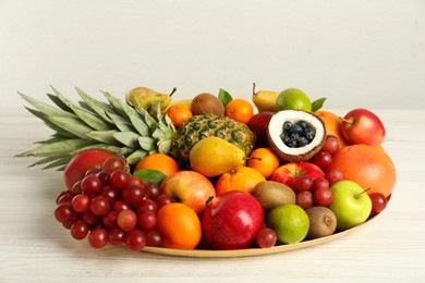 Photo of Platter with different fresh fruits on white wooden table