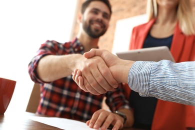 Business partners shaking hands after meeting, closeup
