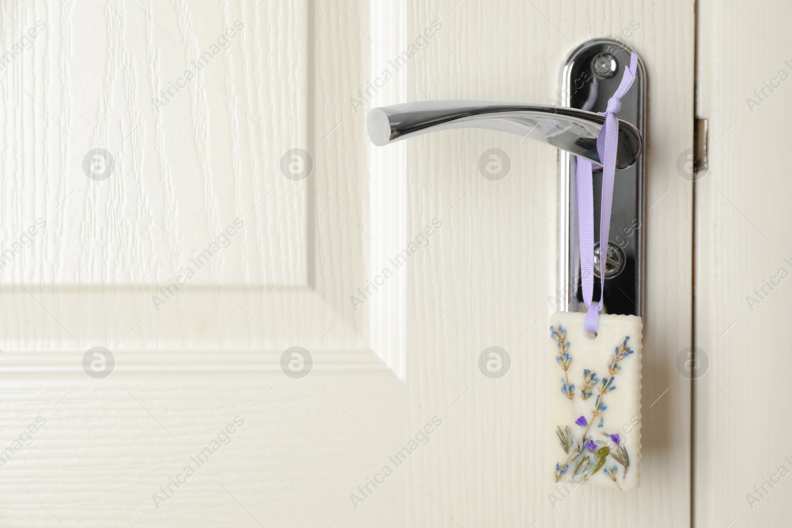 Photo of Scented sachet with flowers hanging on door handle