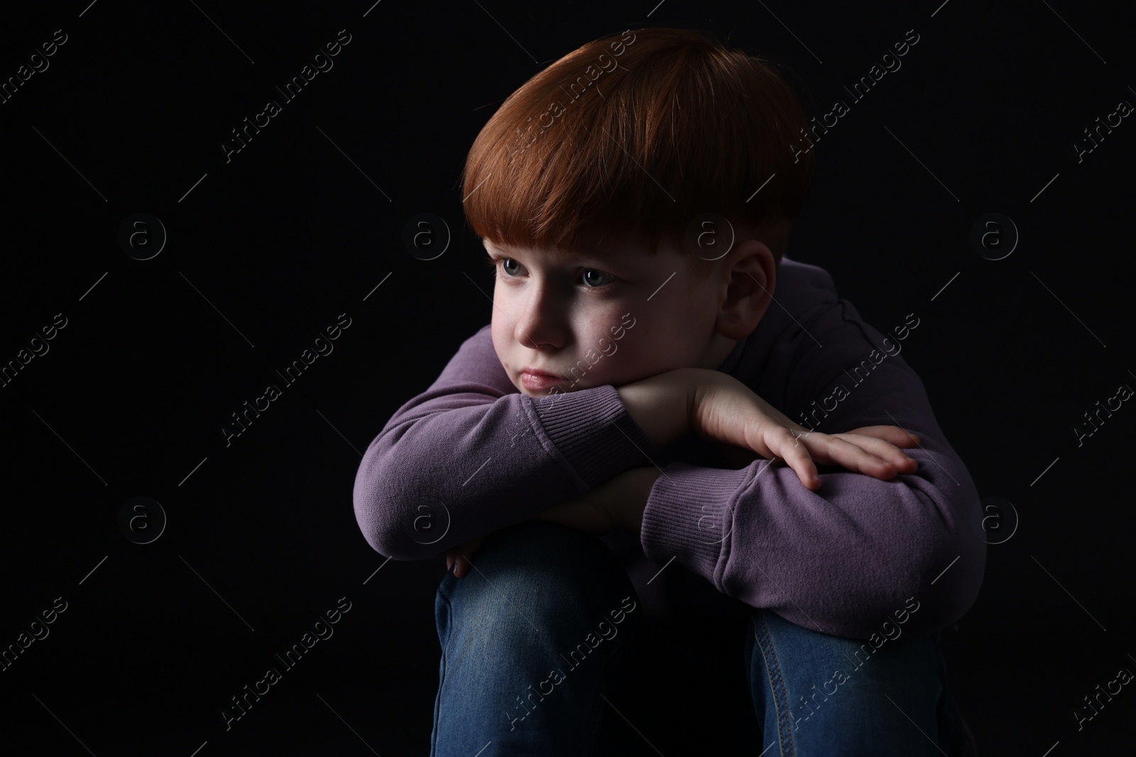 Photo of Portrait of sad little boy on black background, space for text