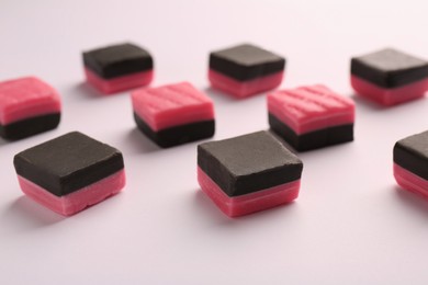 Photo of Tasty liquorice candies on light background, closeup