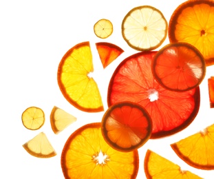 Photo of Illuminated slices of citrus fruits on white background, top view