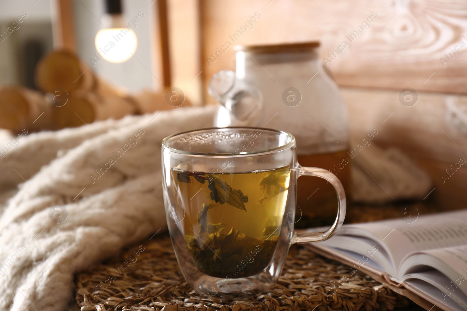 Photo of Freshly brewed tea and open book on table. Cozy home atmosphere