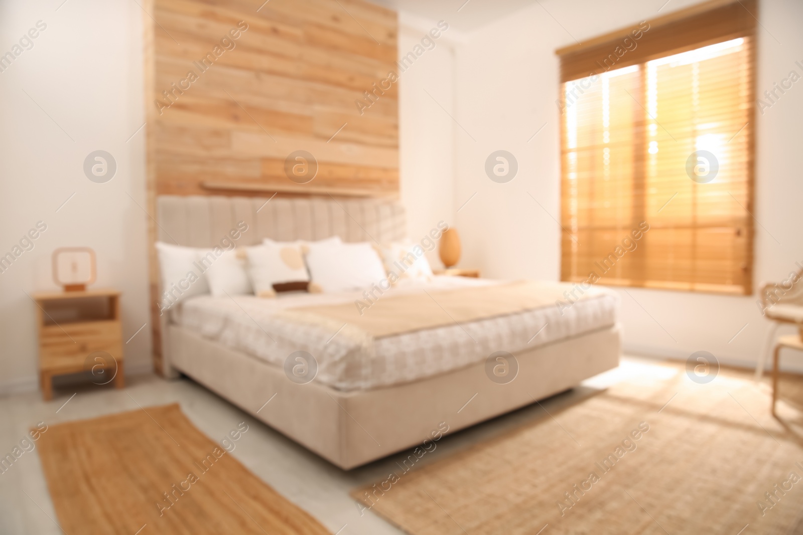 Photo of Blurred view of stylish hotel room interior with comfortable bed