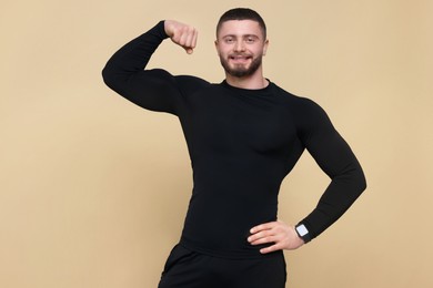 Photo of Handsome sportsman showing muscles on brown background, space for text
