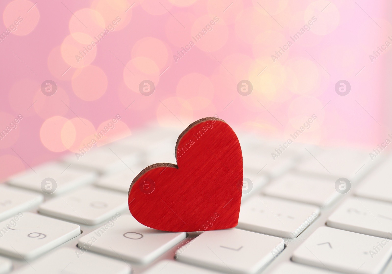 Photo of Red wooden heart on computer keyboard, closeup. Online dating