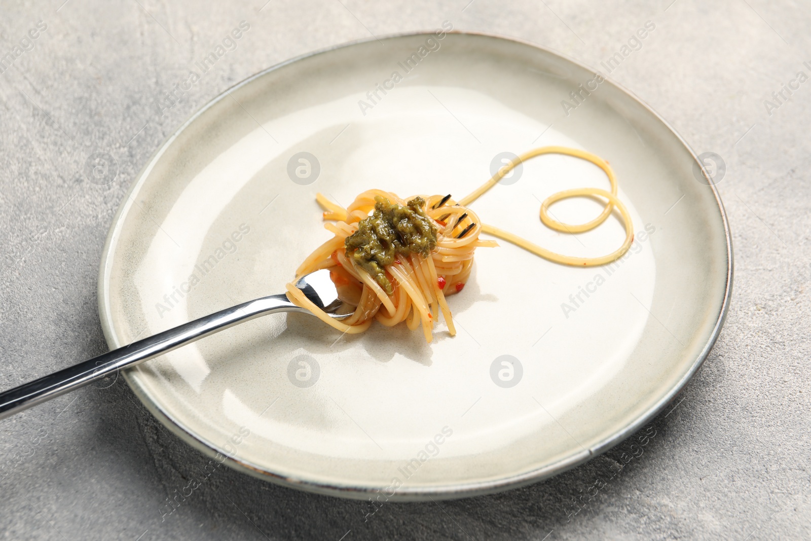 Photo of Heart made with spaghetti and fork on grey table