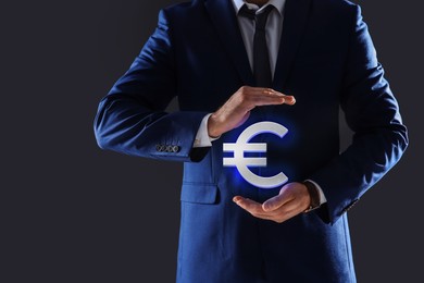 Man demonstrating virtual euro sign on grey background, closeup
