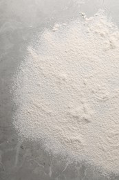 Photo of Pile of flour on grey marble table, top view