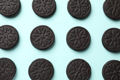 Tasty sweet sandwich cookies on light blue background, flat lay