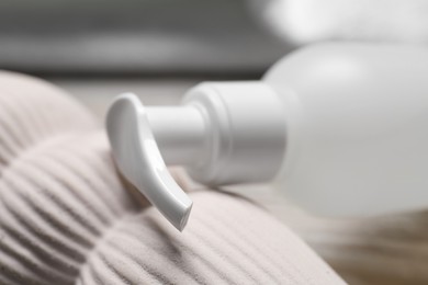 Photo of Bottle of face cleansing product on blurred background, closeup