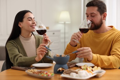 Affectionate couple enjoying chocolate fondue during romantic date at home