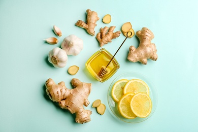 Photo of Ginger and other natural cold remedies on turquoise table, flat lay