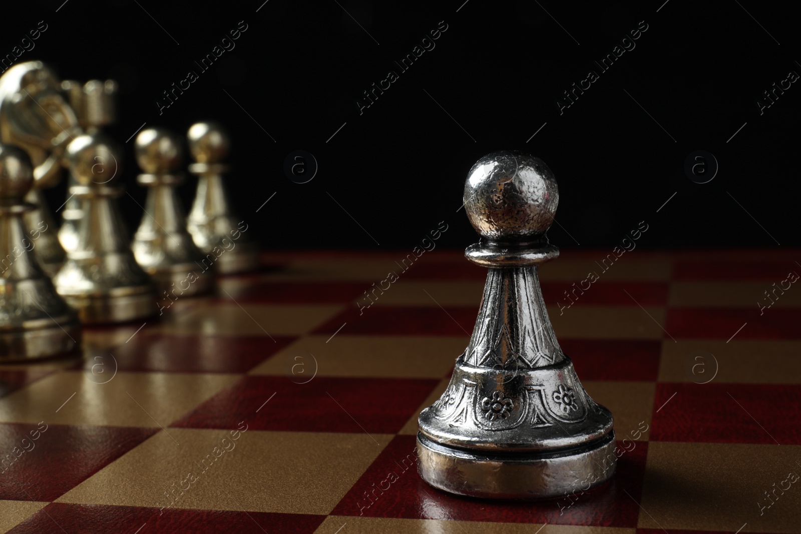 Photo of Chessboard with game pieces on black background, closeup