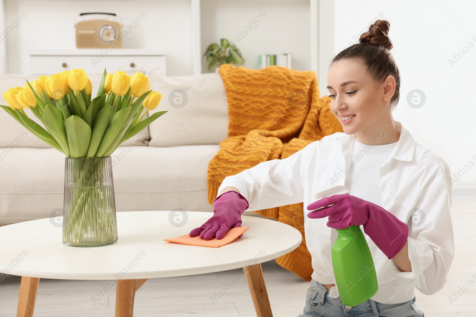 Photo of Spring cleaning. Young woman tidying up living room at home