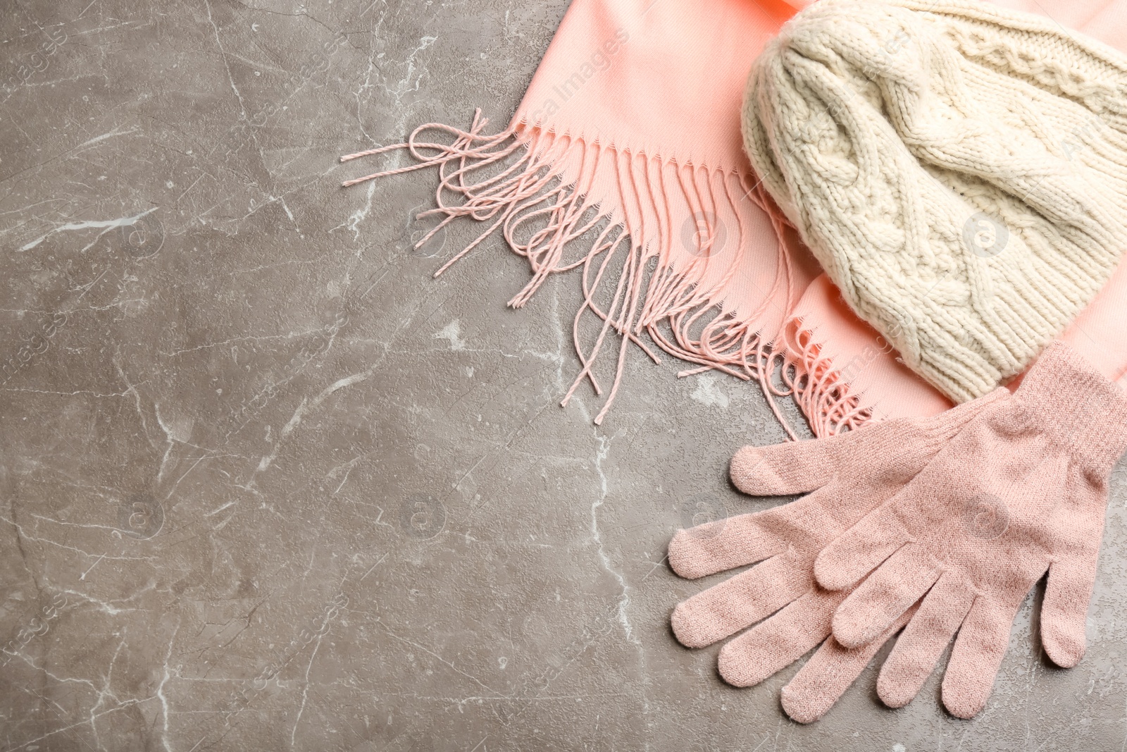 Photo of Stylish pink gloves, scarf and hat on light grey marble table, flat lay. Space for text