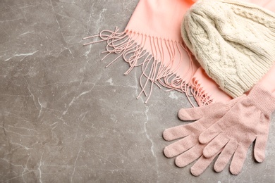 Stylish pink gloves, scarf and hat on light grey marble table, flat lay. Space for text