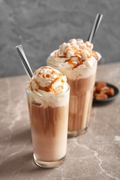 Photo of Glasses with delicious caramel frappe on table