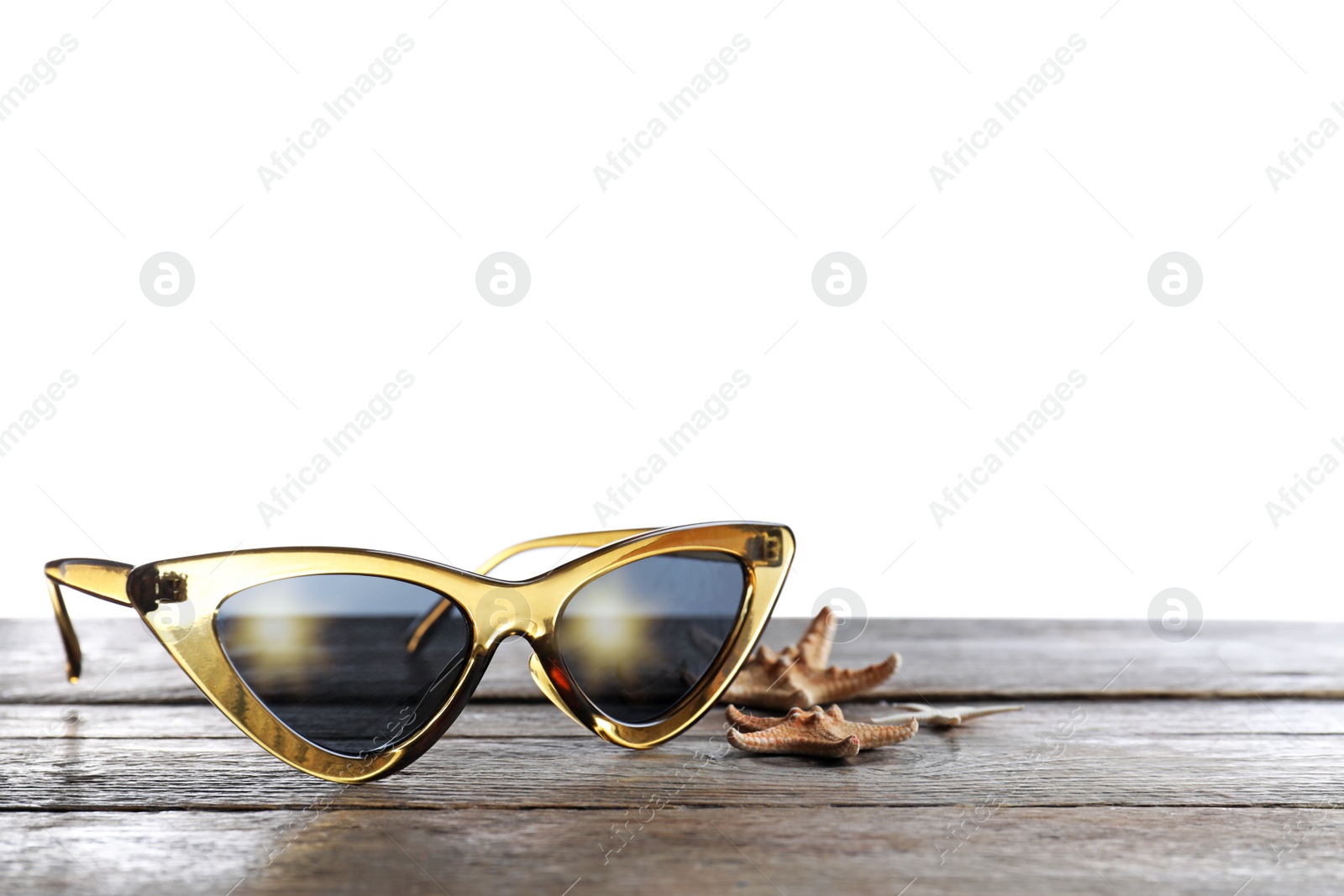 Photo of Stylish sunglasses and starfishes on wooden table against white background. Space for text