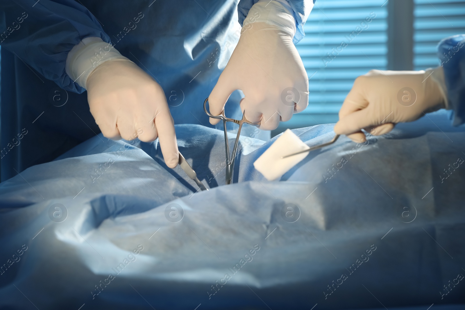 Photo of Professional surgeons with instruments performing operation in clinic, closeup