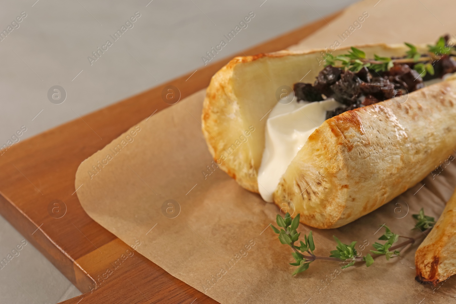 Photo of Tasty baked parsnips with sauce, prunes and thyme on wooden table, closeup. Space for text