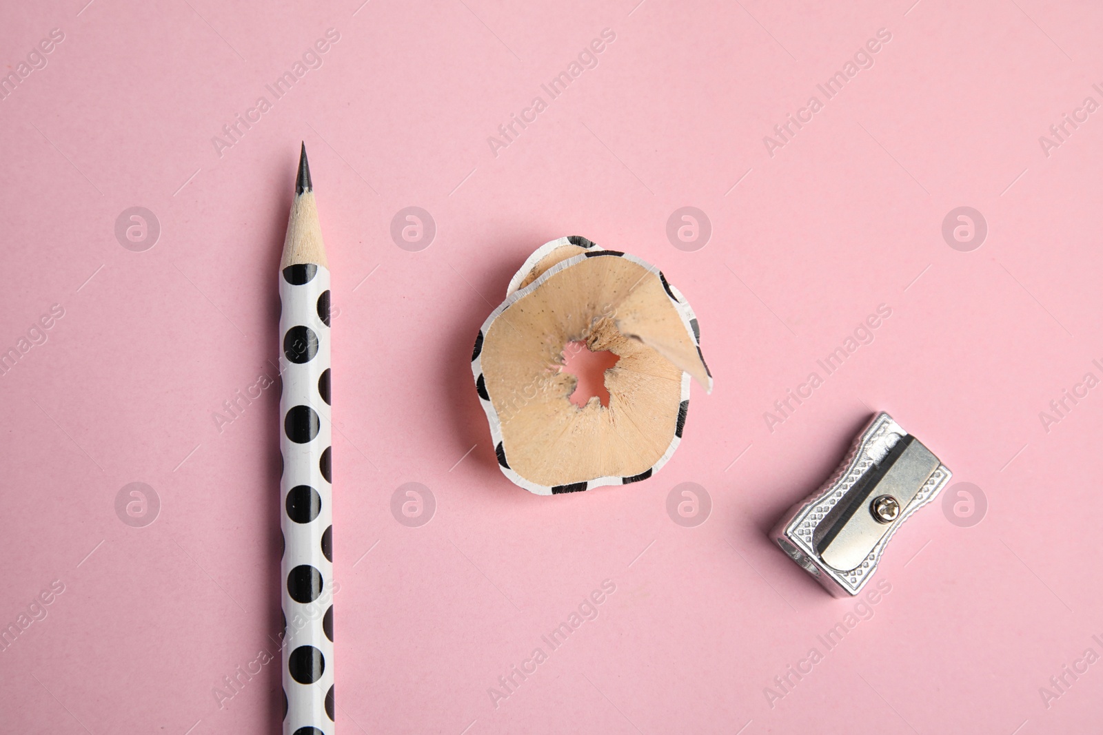 Photo of Pencil, sharpener and shaving on pink background, flat lay