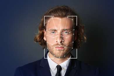 Image of Facial recognition system. Businessman with scanner frame and digital biometric grid on dark background