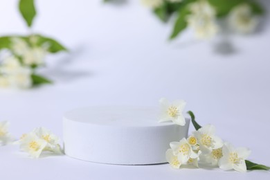 Photo of Presentation of product. Podium and beautiful jasmine flowers on white background