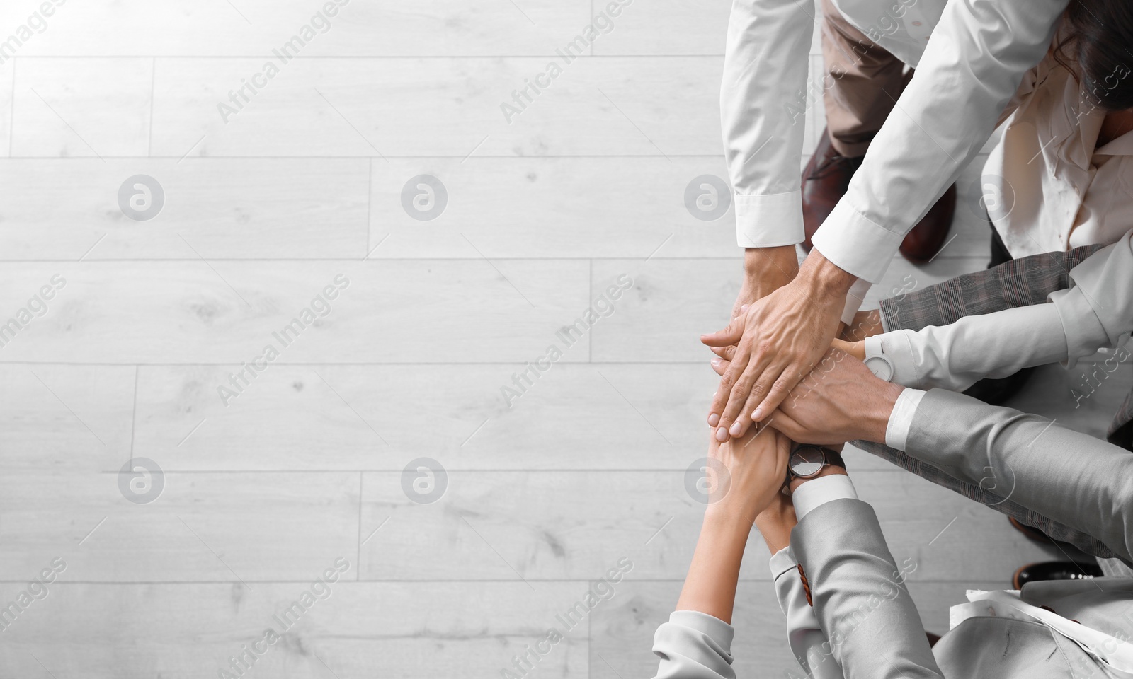 People holding hands together over light wooden background, top view with space for text. Unity concept Photo of People holding hands together over light wooden background, top view with space for text. Unity concept