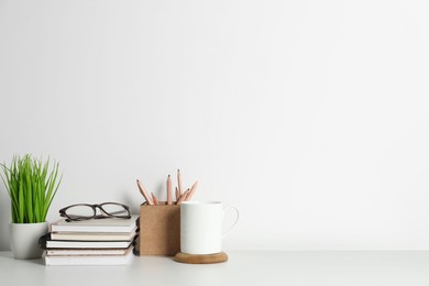 Comfortable workplace with white desk near wall. Space for text