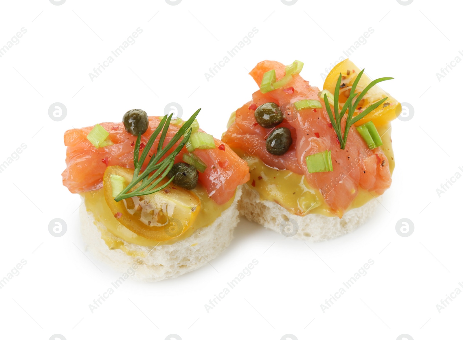 Photo of Tasty canapes with salmon, tomatoes, capers and herbs isolated on white