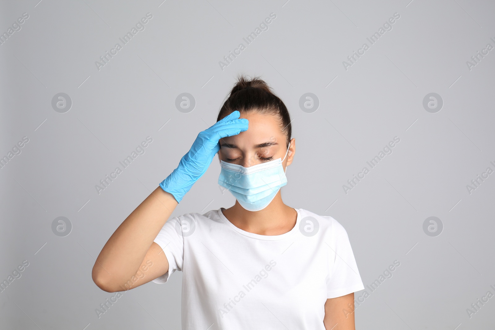 Photo of Stressed woman in protective mask on grey background. Mental health problems during COVID-19 pandemic