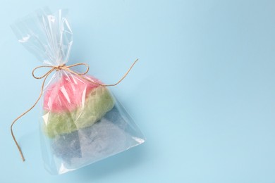 Packaged sweet cotton candy on light blue background, top view. Space for text