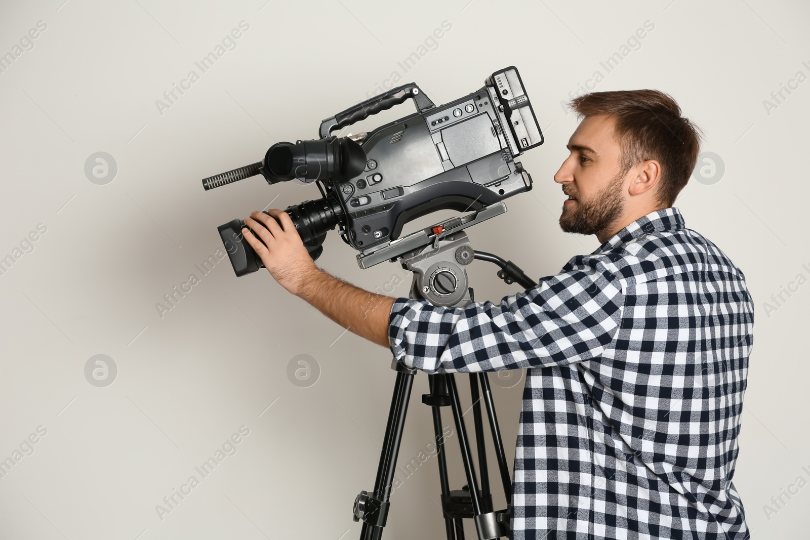 Photo of Operator with professional video camera on white background