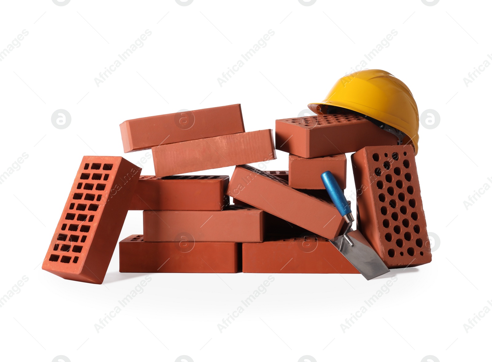 Photo of Many red bricks, hard hat and trowel on white background