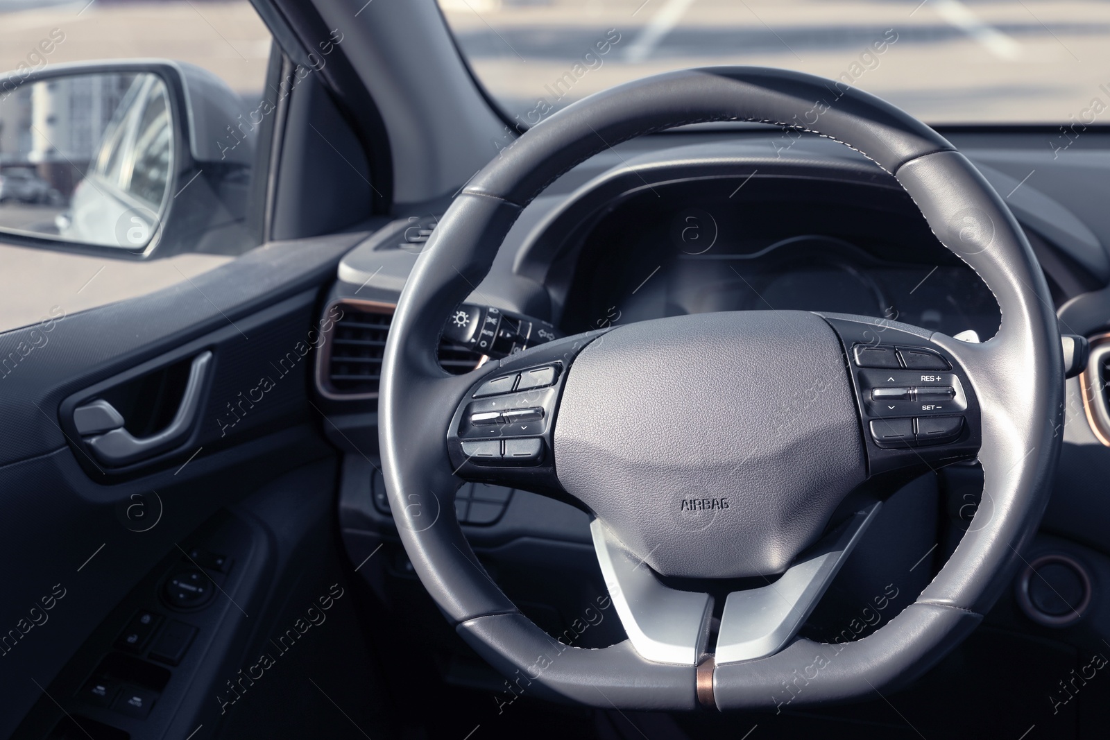 Photo of Black steering wheel and dashboard in modern car