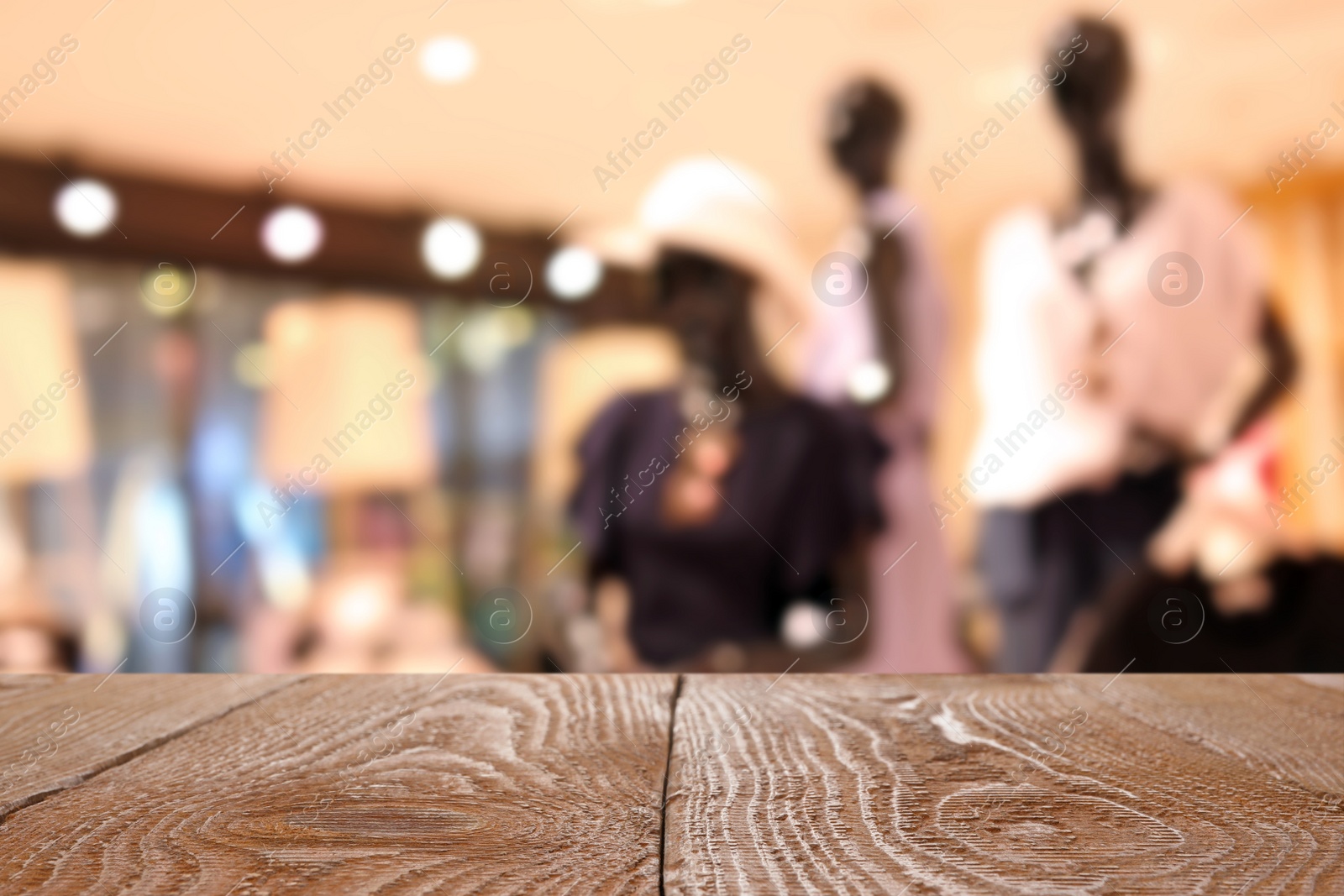 Image of Empty wooden table and blurred view of store with modern clothes