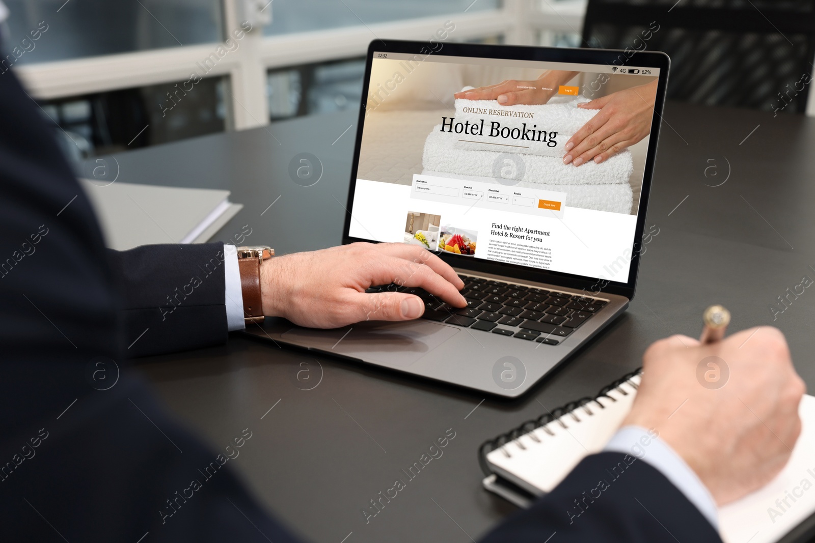 Image of Man using laptop to book hotel at black table, closeup