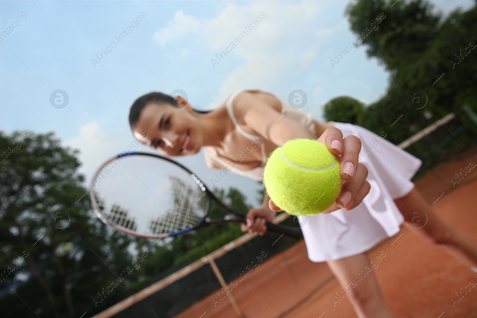 Photo of Woman playing tennis at court, focus on hand with ball