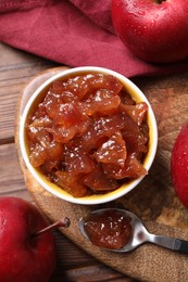 Bowl of delicious apple jam and fresh fruits on wooden table, flat lay