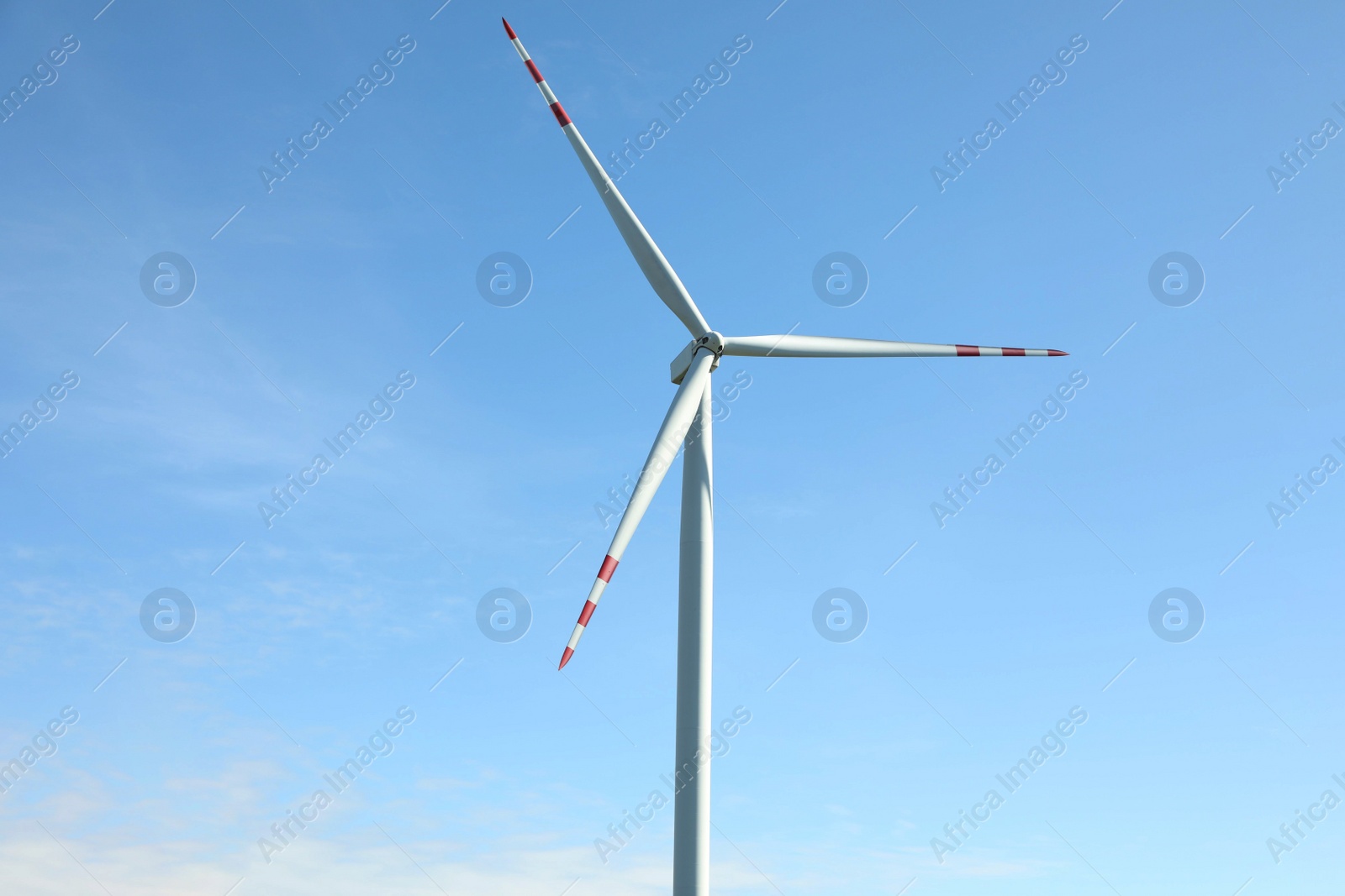Photo of Modern wind turbine against blue sky. Alternative energy source
