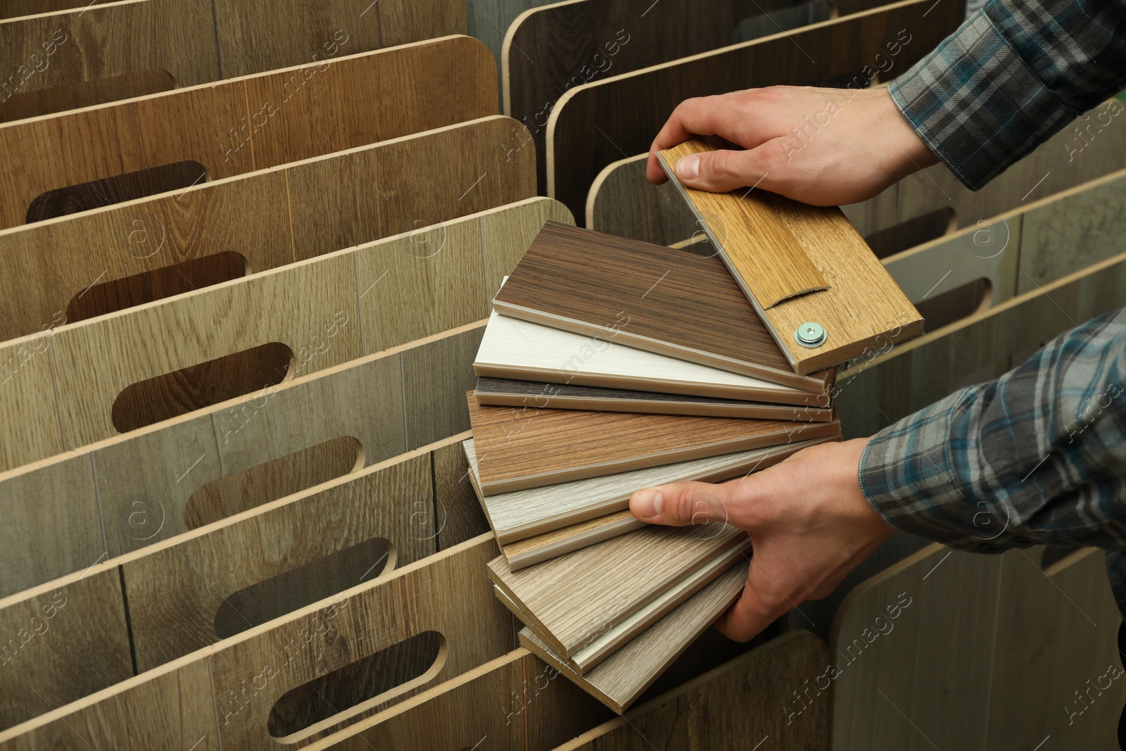 Photo of Man with samples of wooden flooring in shop, closeup