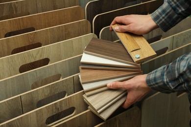 Man with samples of wooden flooring in shop, closeup